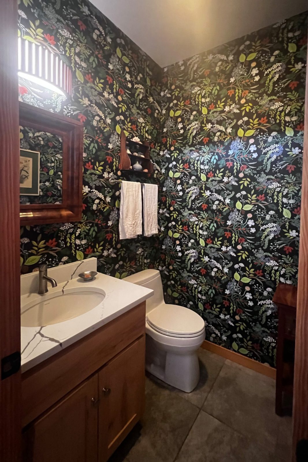 Valentine Drive powder room after remodel — marble vanity and bold botanical wallpaper